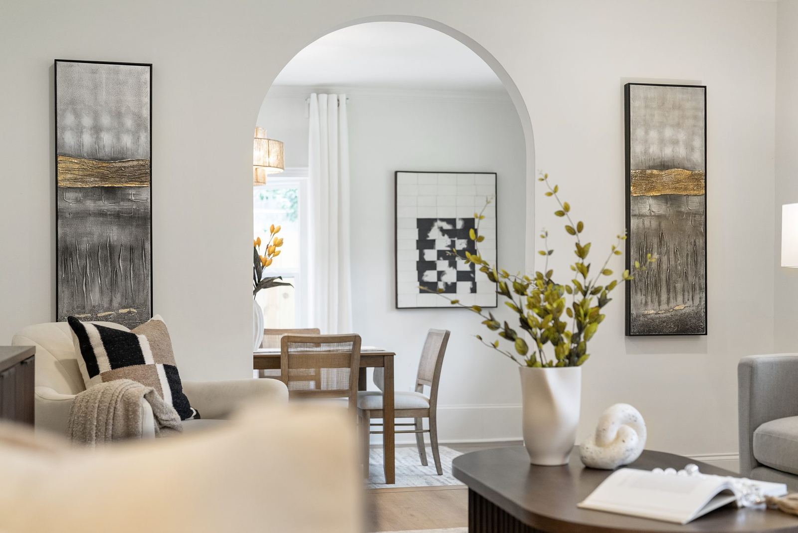 Renovated living and dining area with a large arched structural opening