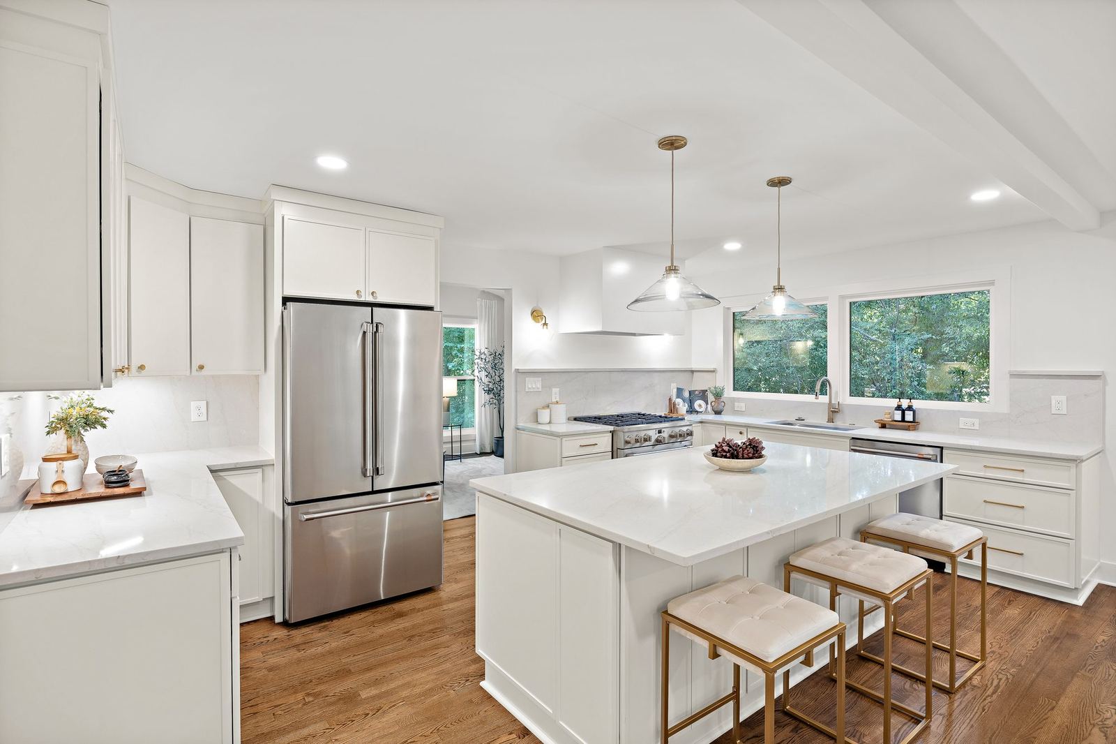 Completed white kitchen renovation with a large island and custom cabinetry
